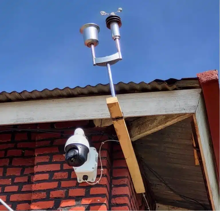 A security camera and a weather station sensor mounted on a brick building for the Governors Island Climate Solutions Challenge.